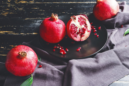 Plate with tasty pomegranate on dark tableの写真素材