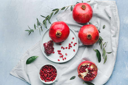 Tasty pomegranate with leaves on light backgroundの写真素材