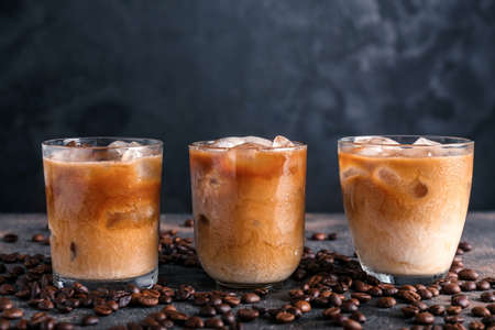 Glasses of tasty cold coffee on dark background