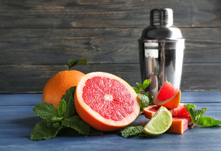 Fresh grapefruits, lime and shaker on tableの写真素材