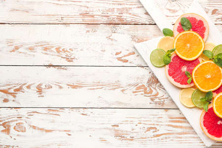 Fresh cut citrus fruits on wooden backgroundの写真素材