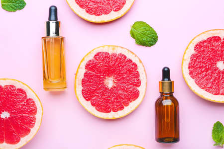 Composition with grapefruit essential oil on color backgroundの写真素材