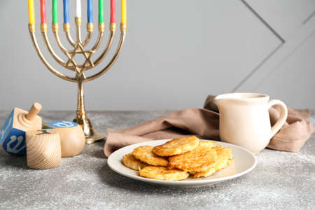 Menorah, potato pancakes and dreidels for Hanukkah on tableの写真素材