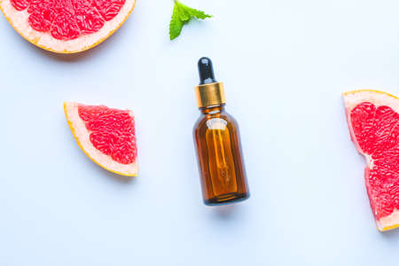 Bottle of grapefruit essential oil on light backgroundの写真素材