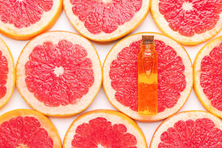 Bottle of essential oil on grapefruit slicesの写真素材