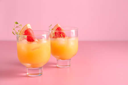 Glasses of fresh citrus juice on color backgroundの写真素材