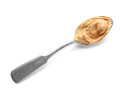 Spoon with tasty peanut butter on white backgroundの写真素材