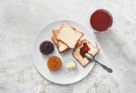 Sweet toasts with butter and jam on tableの写真素材