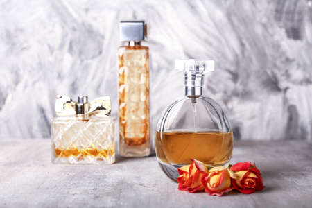 Bottles of perfumes with rose flowers on grunge backgroundの写真素材
