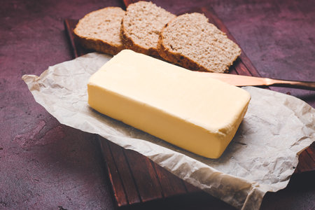 Tasty fresh butter and bread on table
