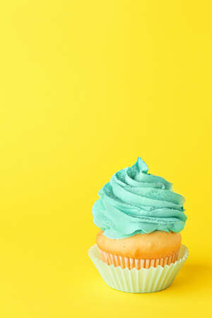 Tasty cupcake on color background