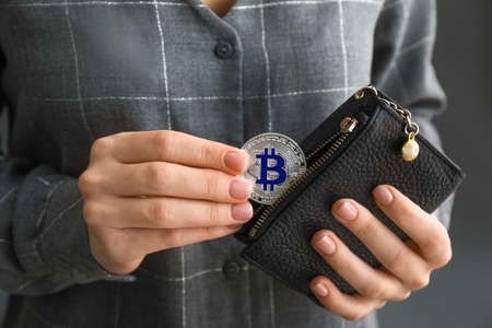 Woman taking bitcoin out from wallet, closeupの写真素材
