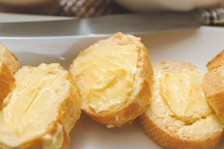 Plate with tasty bread and butter on tray, closeup