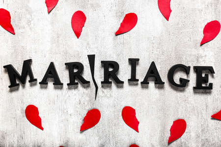 Word MARRIAGE with crack and broken hearts on gray background. Concept of divorceの写真素材