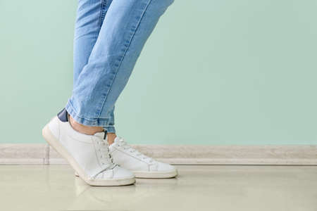 Young man in stylish shoes near color wall