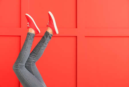 Young woman in stylish shoes on color backgroundの写真素材