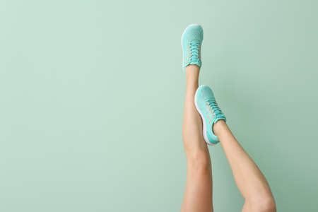 Young woman in stylish shoes on color backgroundの写真素材