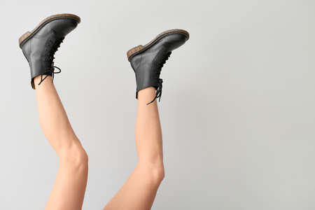 Young woman in stylish shoes on light backgroundの写真素材