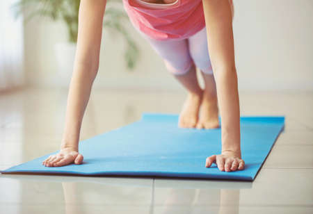 Beautiful young woman practicing yoga at home