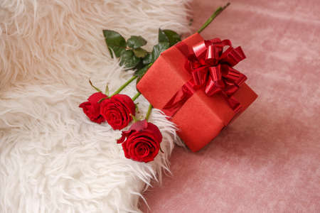 Gift for Valentine's Day and flowers on armchair
