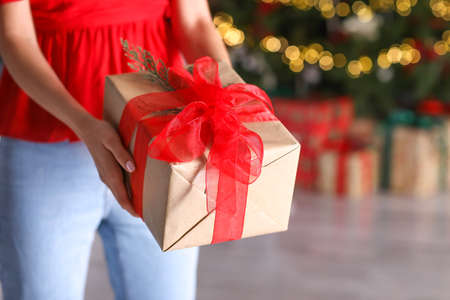 Beautiful young woman with Christmas gift at home, closeupの写真素材