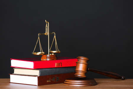 Scales of justice with judge's gavel and books on table