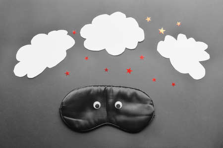 Funny composition with sleep mask on dark background