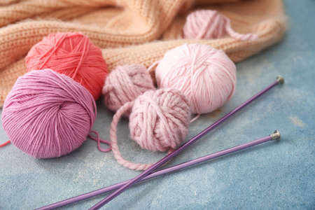 Knitting yarn and needles on color background