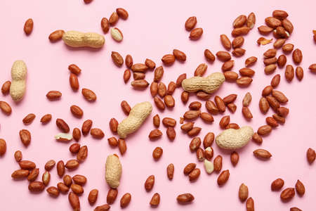 Tasty peanuts on color background
