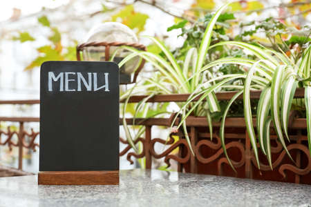 Empty menu board on table in outdoor cafeの写真素材