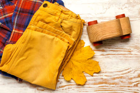 Stylish autumn kid clothes with toy on white wooden backgroundの写真素材