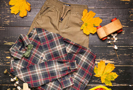 Stylish autumn kid clothes with toys on wooden backgroundの写真素材