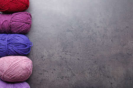 Colorful knitting yarns on gray background