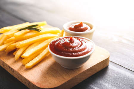 Tasty french fries and tomato sauce on dark tableの写真素材