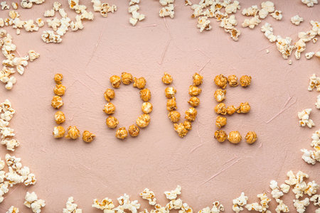 Word LOVE made of tasty popcorn on color backgroundの写真素材