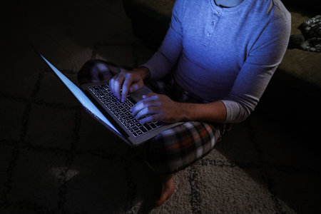 Man with laptop late in evening at homeの写真素材