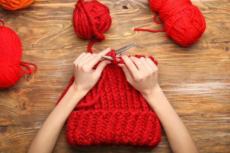 Young woman knitting warm hat at table, top viewの写真素材