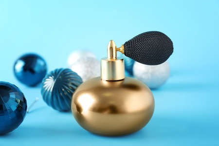 Bottle of perfume and Christmas decor on color backgroundの写真素材