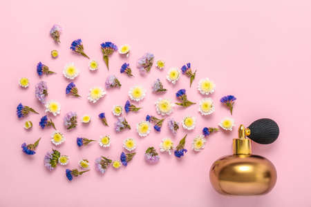 Bottle of perfume and flowers on color backgroundの写真素材
