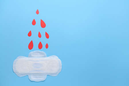 Menstrual pad with red drops on color background. Menstruation conceptの写真素材