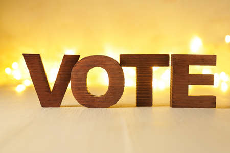 Text VOTE on table against blurred lightsの写真素材