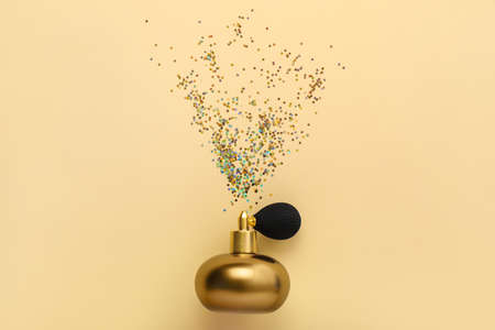 Bottle of perfume and glitters on color backgroundの写真素材