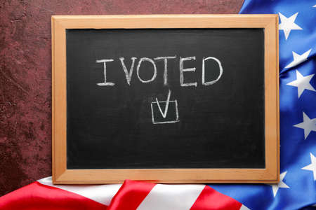 Chalkboard with text I VOTED and USA flag on color backgroundの写真素材