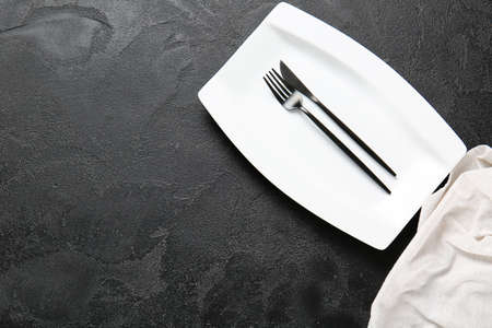Empty plate and cutlery on dark backgroundの写真素材