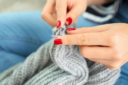 Young woman knitting warm sweater at home closeupの写真素材