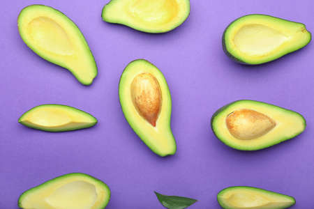 Ripe cut avocados on color backgroundの写真素材