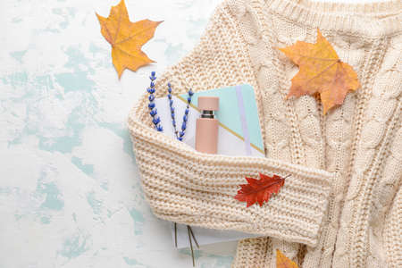 Autumn composition with bottle of perfume and sweater on white backgroundの写真素材