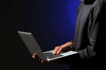Professional hacker with laptop on dark backgroundの写真素材