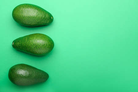 Ripe avocados on color backgroundの写真素材