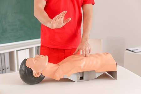 Instructor demonstrating CPR on mannequin at first aid training course